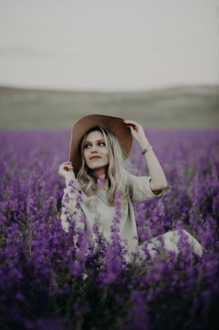Elegant woman relaxing in a vibrant lavender field, exuding tranquility and style.